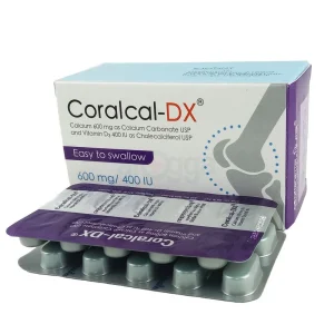A close-up, angled view of a white and purple Coralcal-DX commercial carton by Radiant Pharmaceuticals, positioned behind a metallic silver tablet blister pack showing its purple foil backing.
