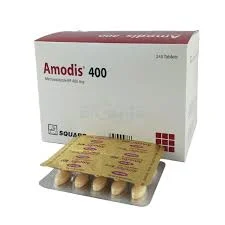 An angled view of a white Amodis 400 prescription box next to three overlapping blister strips, displaying both the printed foil backing and the clear bubble side containing the pills.