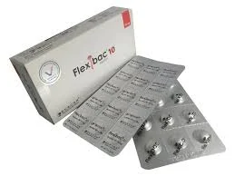 A high-angle shot of a white Flexibac 10 box next to two overlapping silver blister packs, showing one pack from the printed foil side and the other from the transparent bubble side containing the round pills.