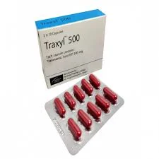 A high-angle shot of a square white and blue Traxyl 500 capsule box standing next to a blister strip containing ten dark red capsules.
